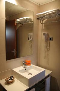 y baño con lavabo y espejo. en Apartaments Aragó565, en Barcelona