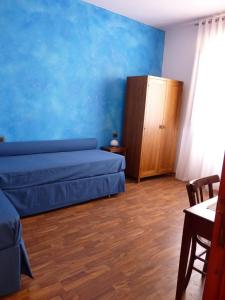- une chambre avec un lit et un mur bleu dans l'établissement Casabettina, à Valderice