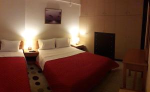 a hotel room with two beds and two lamps at Dreamy Airport's Apartment in Heraklio Town
