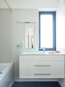 uma casa de banho branca com um lavatório e um espelho em Spring Apartments em Chania