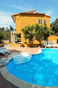 リョレート・デ・マルにあるVilla Dorisの黄色い家の前にある大きな青いプール