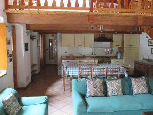 a living room with a blue couch and a kitchen at Appartamento del Sole in Gaby +18 photos