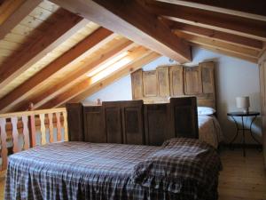 um quarto com uma cama num sótão com vigas de madeira em Appartamento del Sole em Gaby