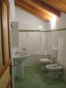 a bathroom with a sink and a toilet and a tub at Appartamento del Sole in Gaby