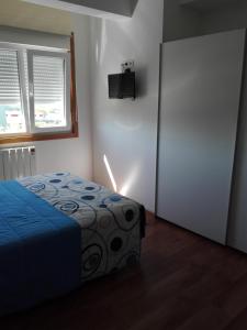サンティアゴ・デ・コンポステーラにあるCancelas 94のベッドルーム1室(青い毛布とドア付)
