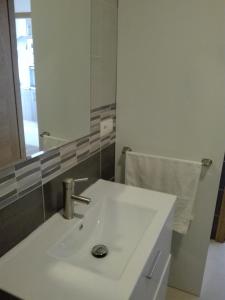 a bathroom with a white sink and a mirror at Cancelas 94 in Santiago de Compostela