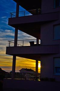 budynek z zachodem słońca w tle w obiekcie Apartments Lalea w mieście Zadar