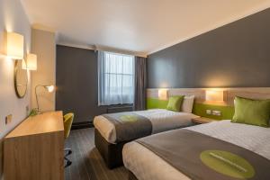a hotel room with two beds and a desk at Thistle Express London Luton in Luton