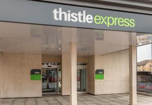 un edificio con una señal que lee el expreso del ajetreo en Thistle Express London Luton en Luton