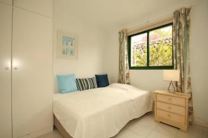 a white bedroom with a bed and a window at Casa Theresa in Los Barros
