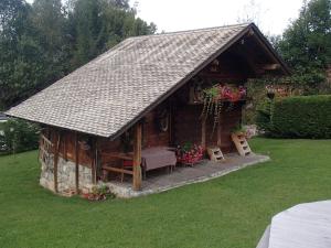 drewniany domek z dachem na trawie w obiekcie Le Grenier w mieście Saint-Paul-en-Chablais