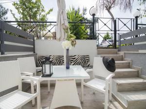 a table and chairs with a vase of flowers on a patio at Frau Irenes Haus in Sarti