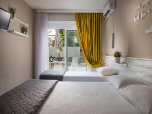 a bedroom with two beds and a yellow curtain at Frau Irenes Haus in Sarti