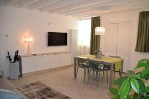 un soggiorno con tavolo e TV a parete di Verona White Lodge a Verona