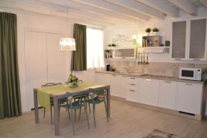 una cocina con mesa y sillas y una cocina con armarios blancos. en Verona White Lodge, en Verona