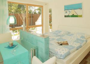 een slaapkamer met een bed, een tafel en een raam bij Ferienappartements Lagune in Bansin