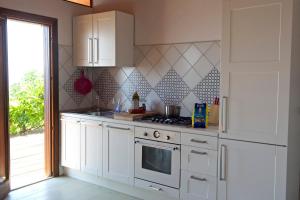 a kitchen with white cabinets and a stove at Casa Paradiso in Terracina