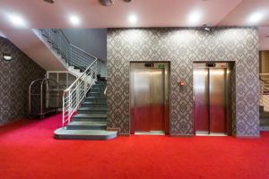 Dos ascensores en un edificio con una alfombra roja en Hotel U Beránka Náchod, en Náchod