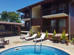 a hotel with a swimming pool in front of a building at Villa Raya in Sozopol