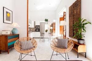 een woonkamer met 2 stoelen en een tafel bij Luxury Rooftop - Space Maison Apartments in Sevilla