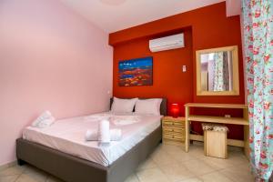 a small bedroom with a bed and a mirror at Grande Apartments in Limenaria