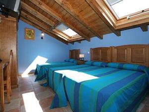 a room with four beds in a room with a blue wall at Hosteria San Emeterio in Isla