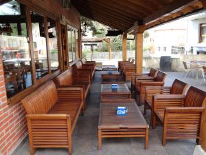 una fila de mesas y bancos de madera en un patio en Hosteria San Emeterio, en Isla