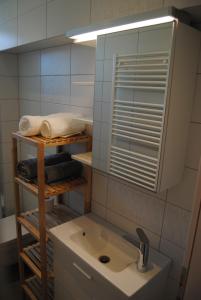 a bathroom with a sink and a mirror and towels at Apartment with Free Parking in Ljubljana