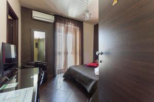 a hotel room with a bed and a sliding door at Beatus Suites And Rooms B&B in Canicattì