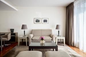 فندق ذا ماندالا في برلين: غرفة معيشة مع أريكة وطاولة
