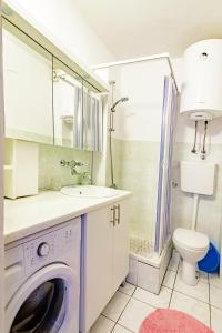 a bathroom with a washing machine and a toilet at Apartments Adriatic in Sveti Stefan