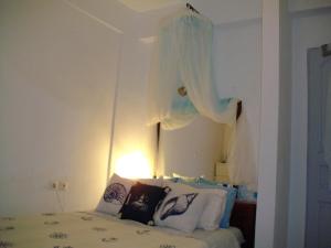 a bedroom with a bed with a curtain above it at Superb view House-Sikinos Island-Chorio in Síkinos