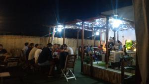 un gruppo di persone sedute al ristorante di notte di Summer Cádiz a Cadice