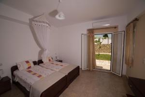a bedroom with a bed and a sliding glass door at Bodikos Villas & Apartments in Pitsidia