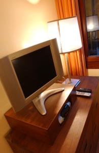 un monitor de ordenador en un escritorio de madera con una lámpara en Ca' Dei Dogi, en Venecia