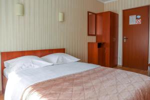 a bedroom with a large bed and a wooden cabinet at Ostrovok Hotel in Saint Petersburg