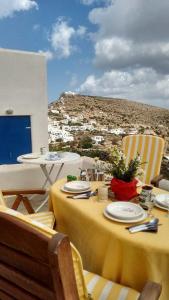 a yellow table with chairs and a view of a city at Superb view House-Sikinos Island-Chorio in Síkinos