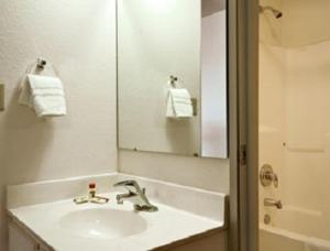 a white bathroom with a sink and a mirror at Days Inn by Wyndham Warsaw in Warsaw