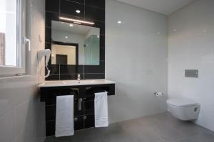 a bathroom with a sink and a toilet and a mirror at Vale de Lourinhã - Casas de Campo in Lourinhã