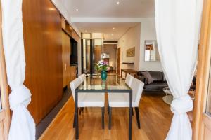 セビリアにあるArtist's Charming Design - Space Maison Apartmentsのガラスのテーブルと白い椅子のあるダイニングルーム +23枚の写真