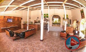 a large room with couches and tables in a building at Recanto do Barao Pousada in Jericoacoara