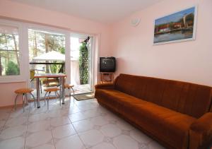 a living room with a brown couch and a table at Guesthouse "Nakvynė pas žveją" Vetrungiu Street 298-2 in Nida