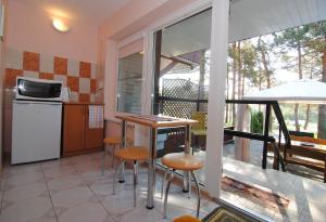 a kitchen with a table and chairs on a balcony at Guesthouse "Nakvynė pas žveją" Vetrungiu Street 298-2 in Nida