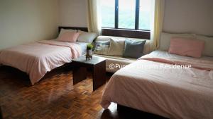 two beds in a room with a window at AFamosa Purple Dream Residence Condotel homestay in Melaka +28 photos