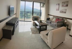 un soggiorno con divano e tavolo di AFamosa Purple Dream Residence Condotel homestay a Malacca