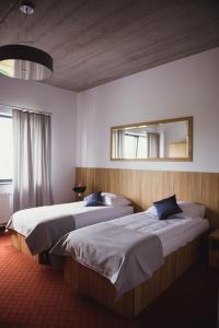 duas camas num quarto de hotel com um espelho em Hotel Turkovia em Turek