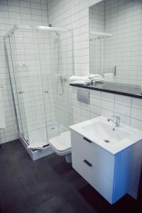 a bathroom with a sink and a shower and a toilet at Hotel Turkovia in Turek