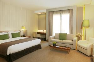 ベイルートにあるParkTower Suitesのベッドとソファ付きの広いホテルルームです。