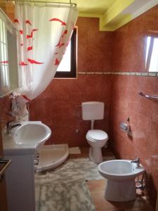 La salle de bains est pourvue de toilettes blanches et d'un lavabo. dans l'établissement Apartment Nela, à Funtana