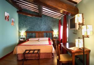 1 dormitorio con cama, mesa y escritorio en Hotel Duques de Najera, en Nájera